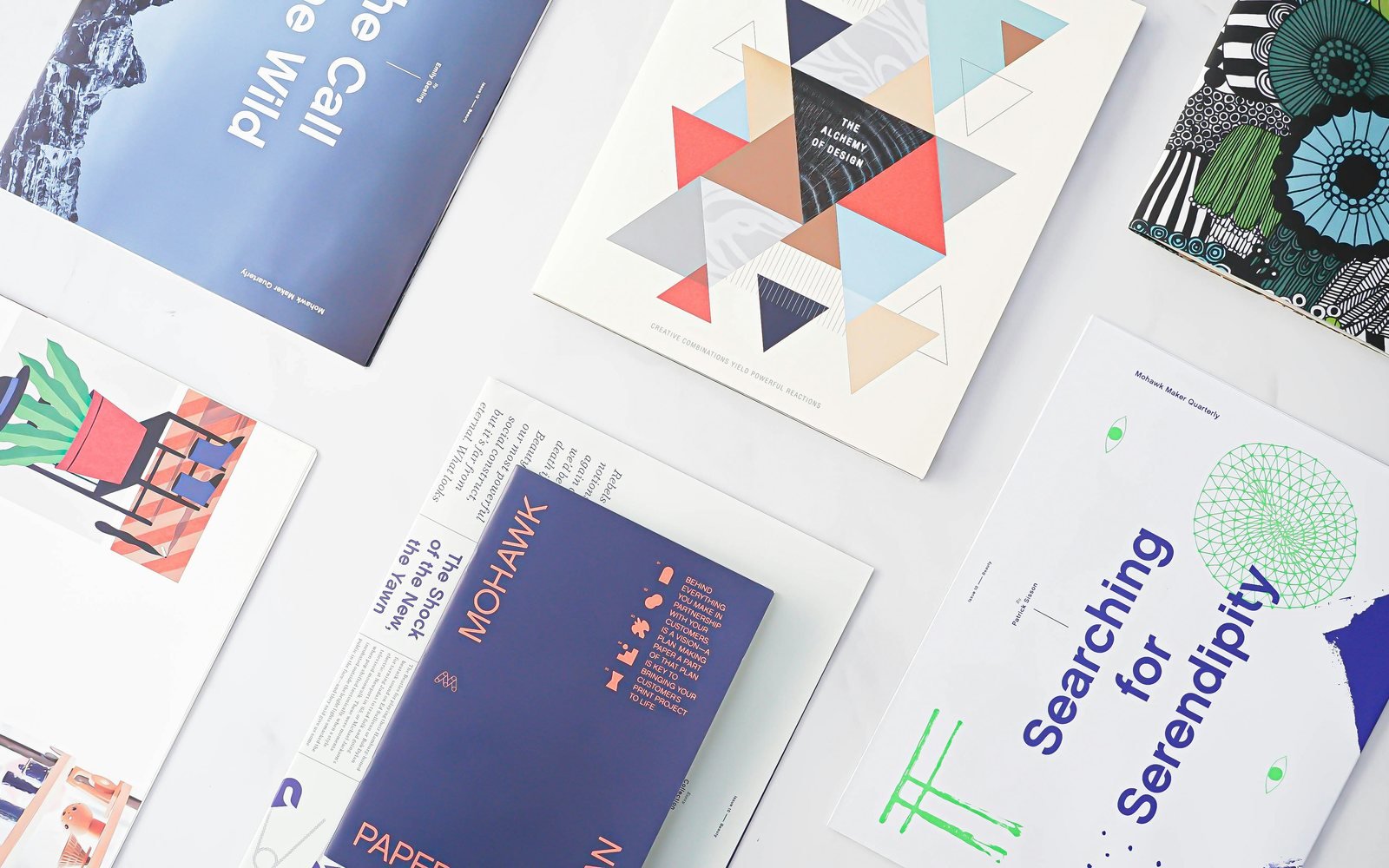 Printed editorial publications and design research material arranged on a table.